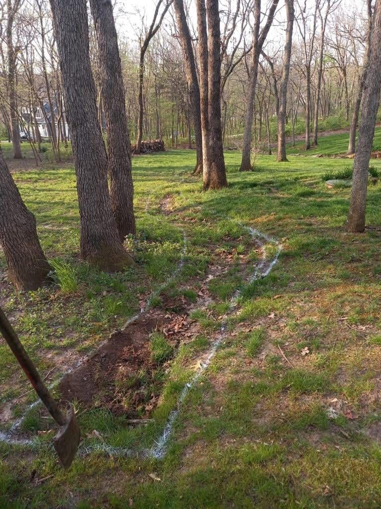 French drain path marked with spray paint before digging
