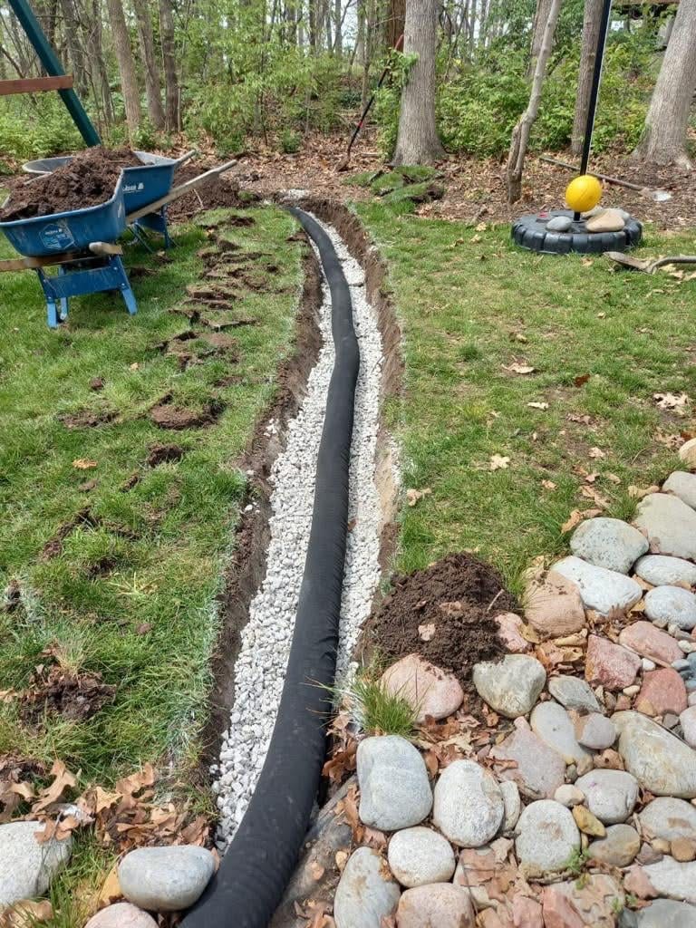 French drain pipe and gravel installed in trench