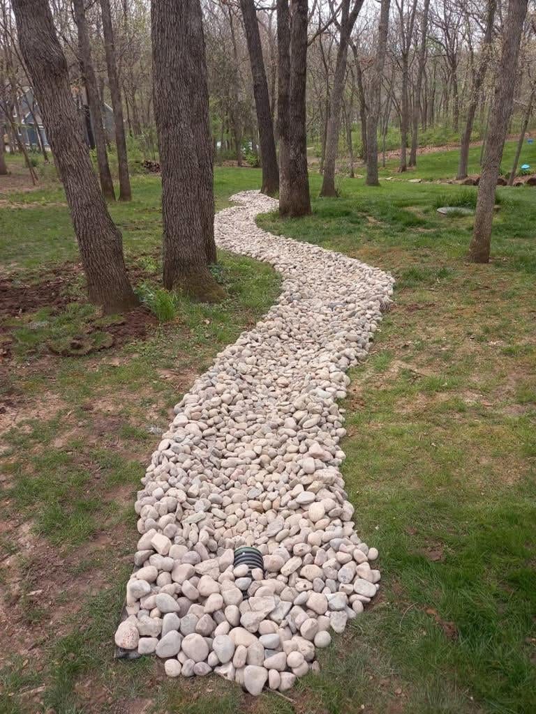 Wide view of completed river rock French drain